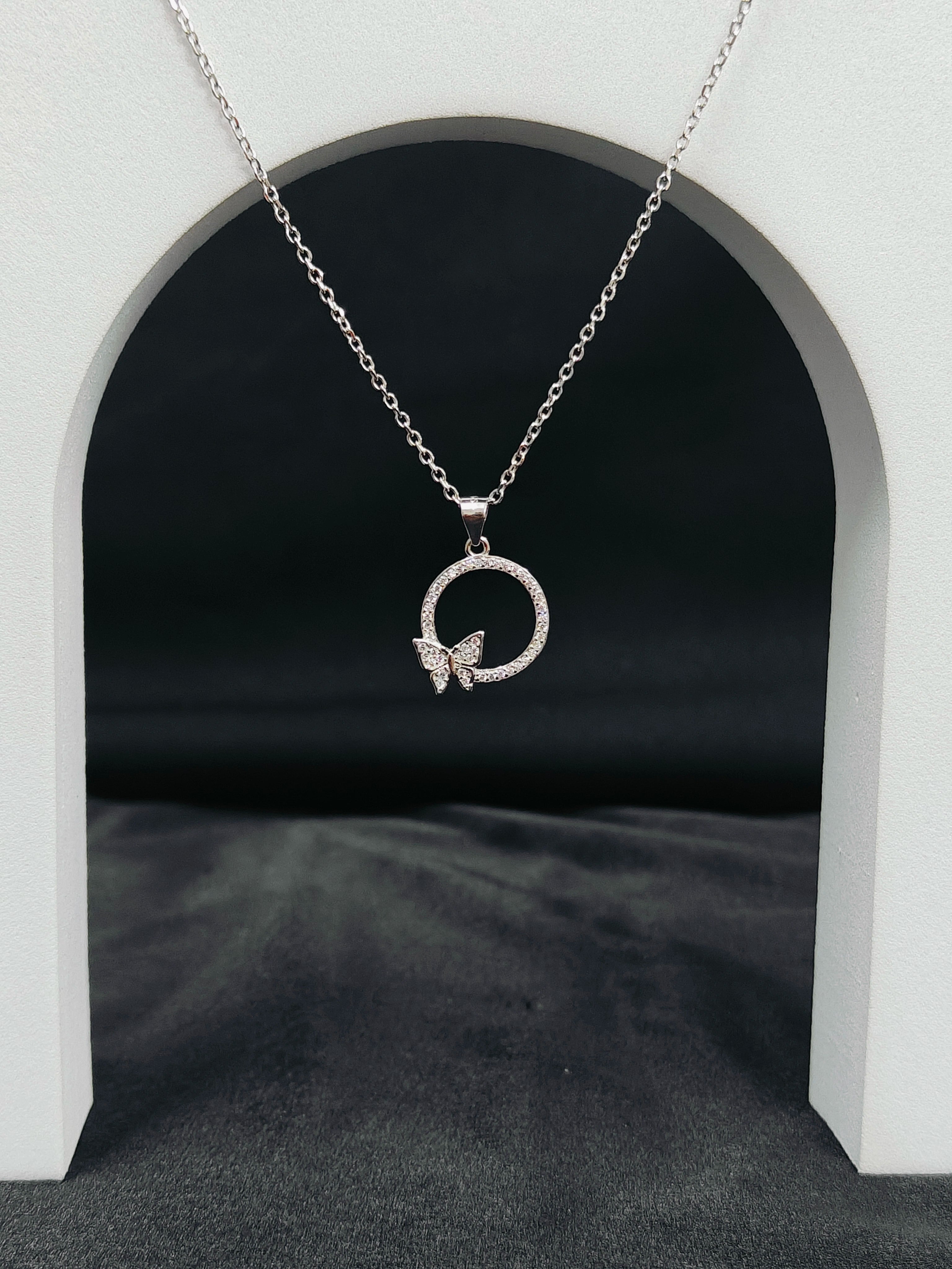 Silver necklace with a butterfly pendant on a dark background